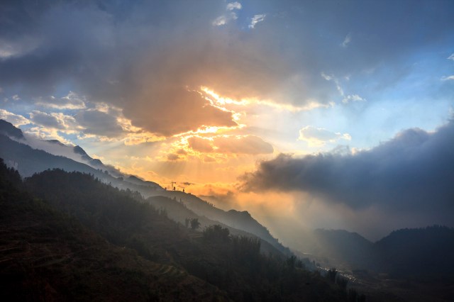 ray of light from heaven shining through the clouds above the mountains